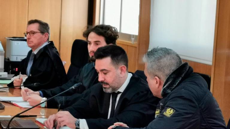 El acusado –a la derecha y de perfil– hablando con su abogado, Isaac González. Foto: Àngel Juanpere