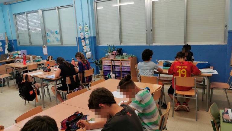 Después de cerrar ventanas y bajar persianas, los alumnos siguen con la clase. Foto: Àngel Juanpere