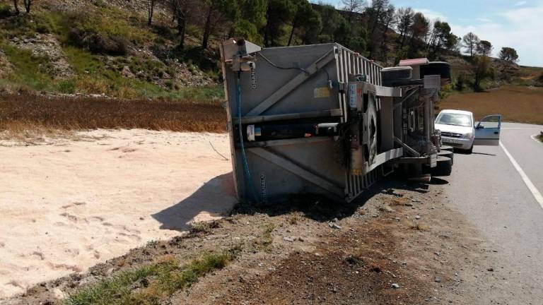 La arena que transportaba el camión ha quedado esparcida por el lateral de la carretera. Foto: Bombers