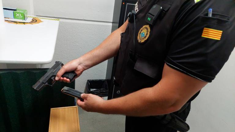 Un policía local comprueba su pistola reglamentaria en la sala donde se guarda el armamento. FOTO: DT