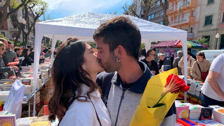 Una pareja de jóvenes frente a una parada de libros. Foto: Pere Ferré