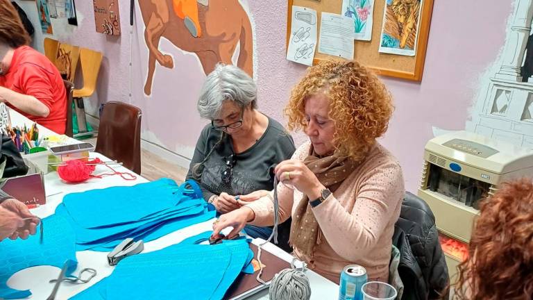 Preparando baberos de calçotada en el taller Activa’t. Foto: AVV El Santuari