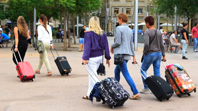 Unas turistas buscan su hospedaje en el barrio de la Barceloneta, en Barcelona. Foto: EFE