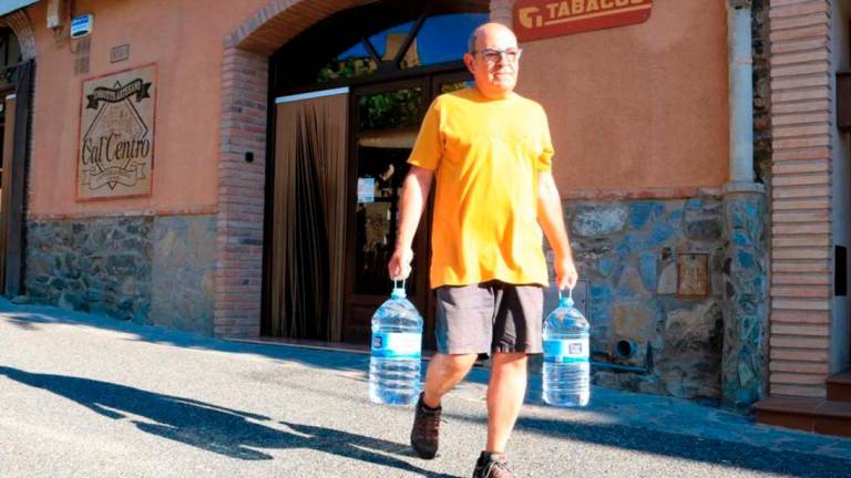 Imagen de archivo de un vecino de la Vilella con dos garrafas con agua potable. Foto: ACN