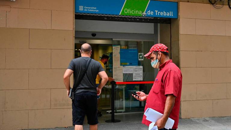 Varias personas, a la entrada de la Oficina de Treball de Reus. Foto: Alfredo González.