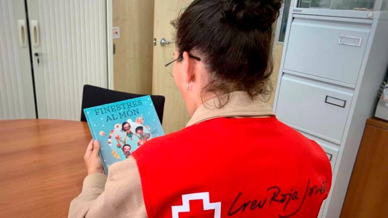 Voluntaria de Creu Roja con un libro que dará a un niño o niña vulnerable este Sant Jordi. Foto: cedida
