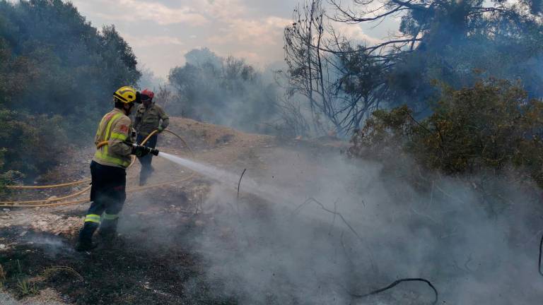 Dos efectivos de Bombers de la Generalitat trabajan en el fuego. Foto: Àngel Juanpere