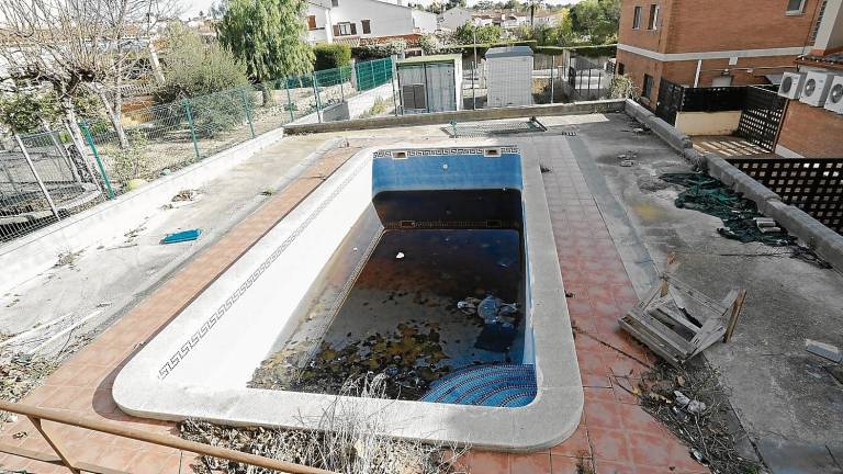 En el interior del edificio hay una piscina en estado de abandono y rodeada de escombros. FOTO: PERE FERRÉ