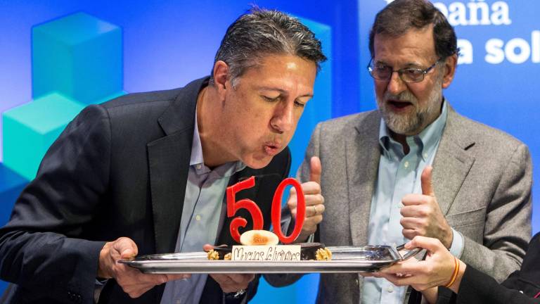 El candidato del PP, Xavier García Albiol, sopla las velas de su 50 cumpleaños, junto al presidente Mariano Rajoy, en el acto de campaña celebrado ayer en Lleida. FOTO: EFE