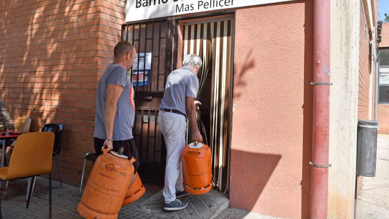 Vecinos del barrio de Reus Sant Josep Obrer entrando en el local social con bombonas de butano. FOTO: Alfredo Gonzélz