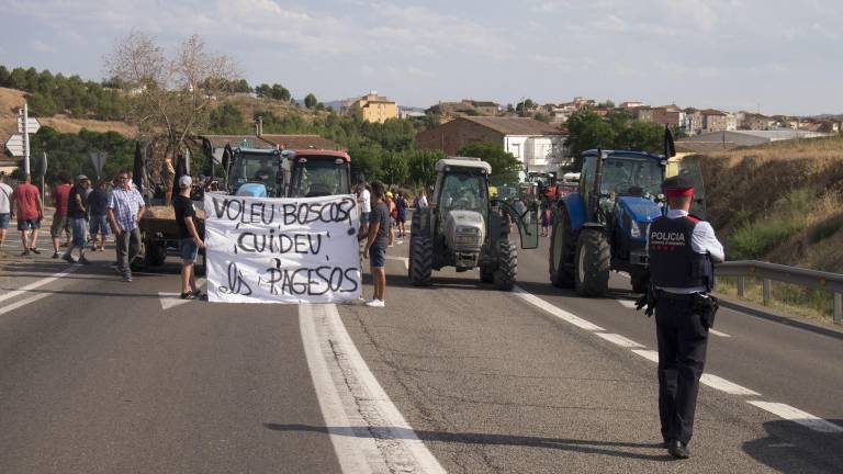 Els pagesos, ahir, tallant la carretera amb els seus tractors. FOTO: J. REVILLAS