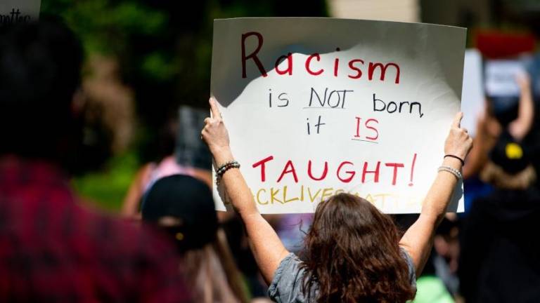 El racismo es una conducta aprendida, reza la pancarta. foto: ACN
