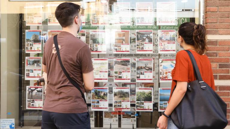 Dos jóvenes mirando ofertas de una inmobiliaria. FOTO: Alba Mariné/DT