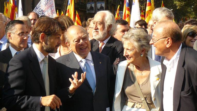 Marta Ferrusola conversando con su marido y su hijo, Jordi y Oriol Pujol, en la parte izquierda de la imagen