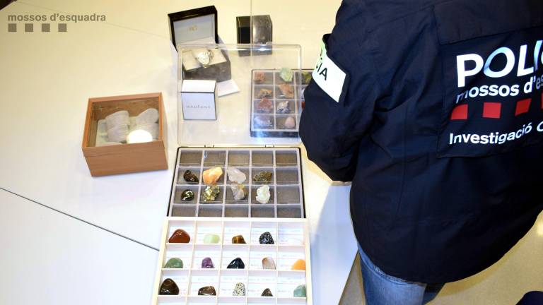 Un agente de los Mossos revisando parte de las colecciones de valor que el agresor robo a la víctima de la Sénia. FOTO: REDACCIÓN
