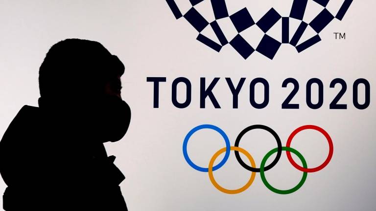 Un ciudadano, con su mascarilla, pasa junto a un cartel oficial de los Juegos Olímpicos, esta semana en Tokyo. FOTO: EFE