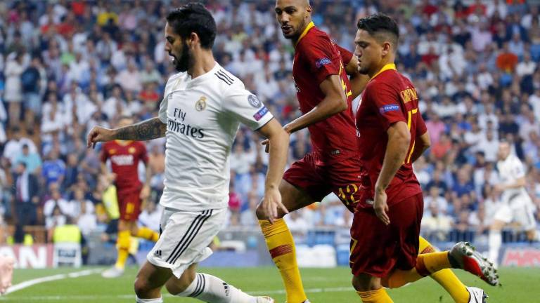 El centrocampista del Real Madrid, Isco Alarcón, controla pelota ante dos jugadores de la Roma. FOTO: EFE