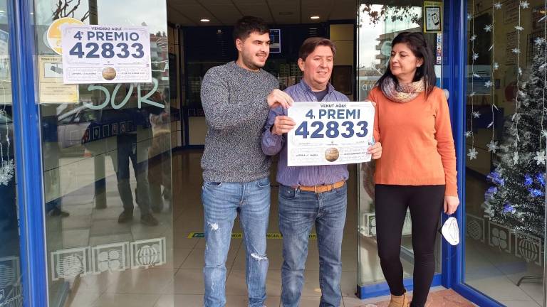 Rubén Mateo (centro) y su familia, con el número premiado. FOTO: PERE FERÉ