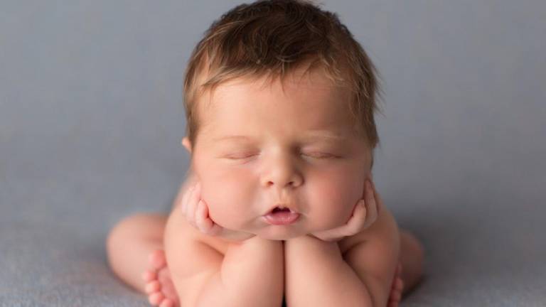 Foto de estudio de un bebé en posición de pensar