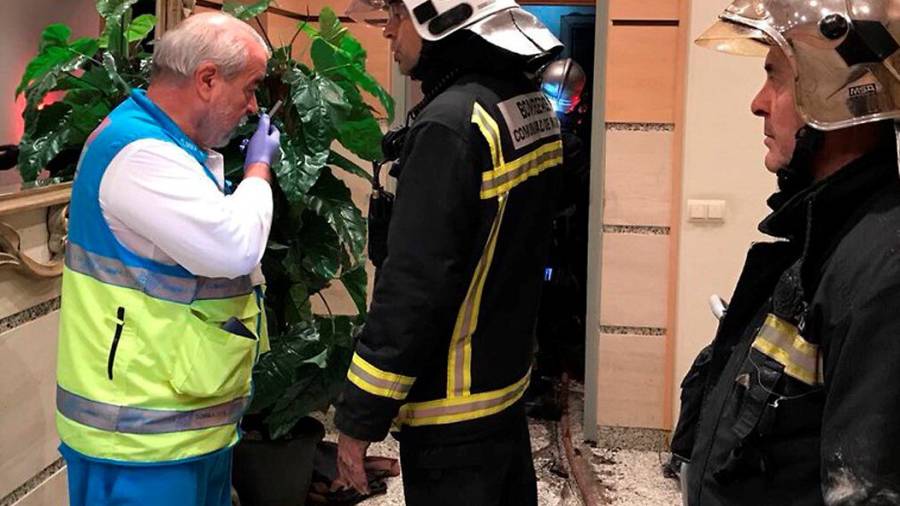 Fotograf&iacute;a cedida por la Comunidad de Madrid de un miembro del SUMMA y varios bomberos en la puerta de la vivienda en la que dos menores han sido encontrados muertos
