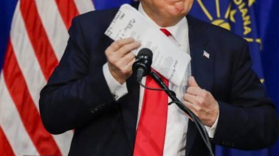 Donald Trump saca sus apuntes de un bolsillo antes de hablar en un acto de campaña. Foto: efe