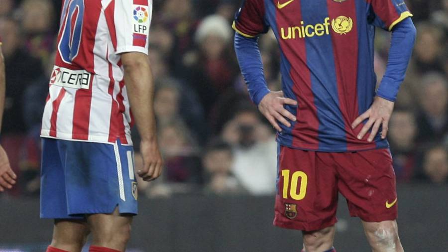 El Kun Agüero con la camiseta del Atlético de Madrid charla con el delantero del FC Barcelona Leo Messi durante el transcurso de un partido entre los dos clubes. Si Leo renueva ambos argentinos compartirán vestuario.