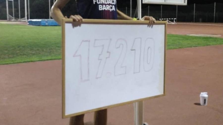 Galimany, sosteniendo el cartel con la cifra del récord de distancia. Foto: Federació Catalana d'Atletisme