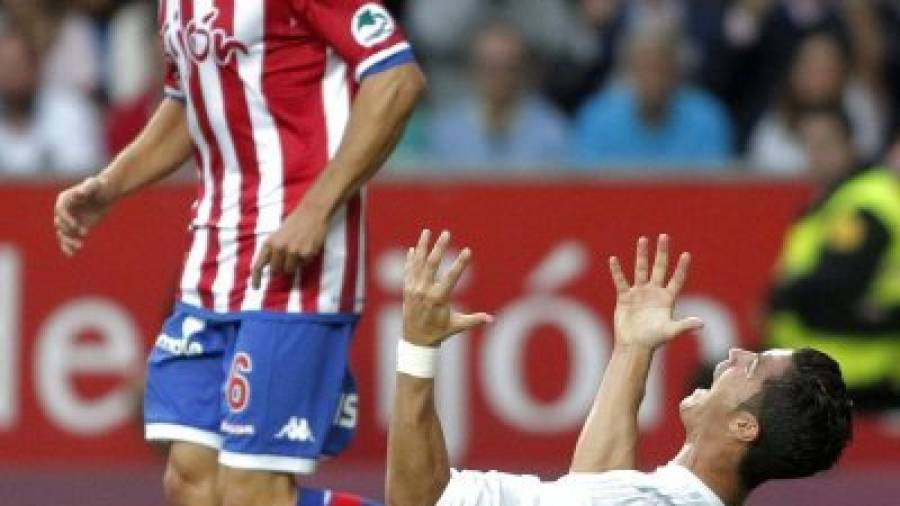 Cristiano Ronaldo reclama penalti ante el defensa Isma López, del Sporting de Gijón, durante el partido de ayer. Foto: efe