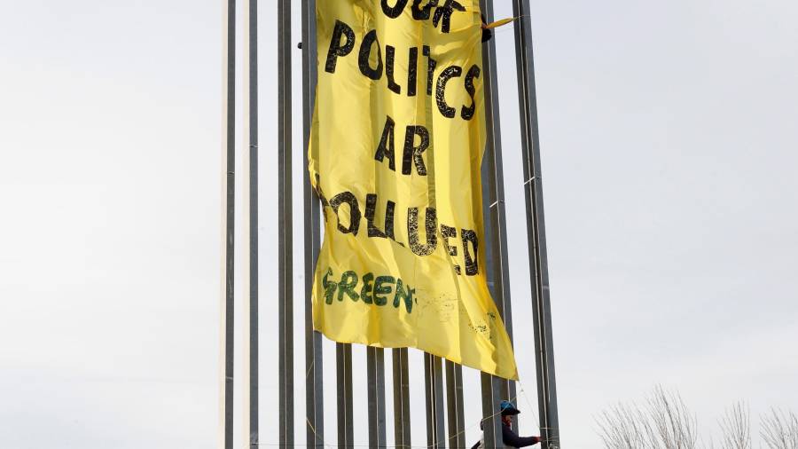 Activistas de Greenpeace desplegaron una pancarta en una torre de iluminación de Ifema. zipi/efe