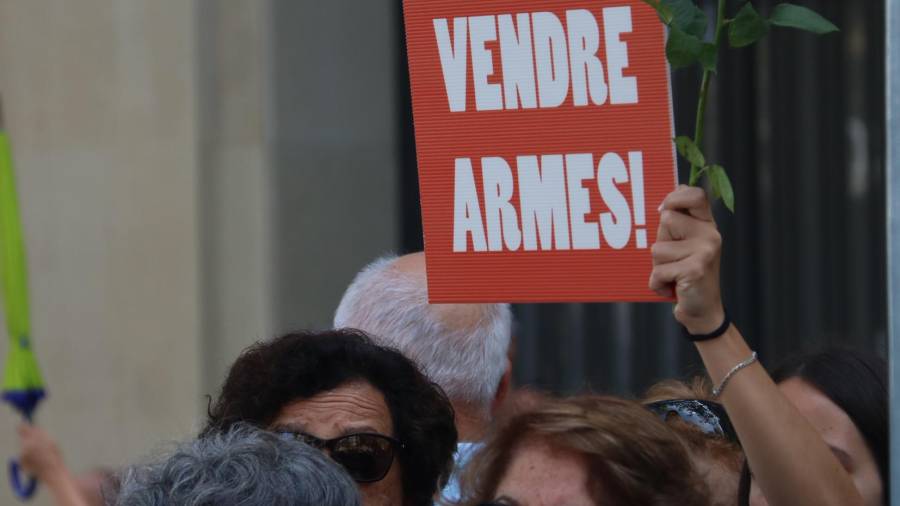 Una dona subjecta un cartell a favor de la pau i en contra de la venda d'armes a la manifestació de rebuig del terrorisme a Barcelona del 26 d'agost del 2017. Pla mig.