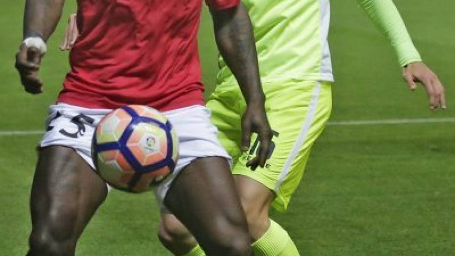 El jugador grana Achille Emaná protege el cuero ante la presión de un futbolista del Elche. FOTO: LLUÍS MILIÁN