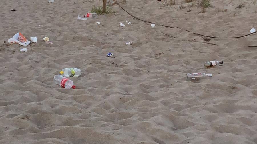 Restos de un botellón en la arena, frente al Nàutic Creixell.