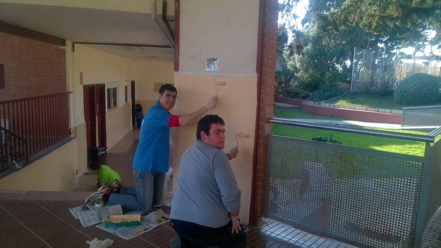 Jordi Recasens (de azul) pintando una escuela. FOTO: CEDIDA FOTO:PERE FERRÃ‰