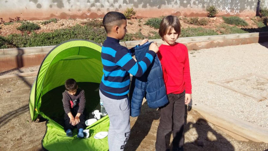 Els nens han sortit al pati per simular la vida dels refugiats. L'objectiu de tot plegat, la conscienciació, en el marc del Dia de la Pau. Foto: Cedida