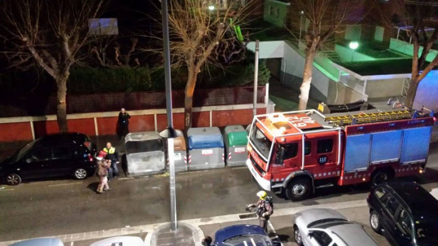 Bomberos y Guàrdia Urbana poco después de haber sofocado el incendio en un contenedor de la calle Joan Baptista Plana. Foto: DT