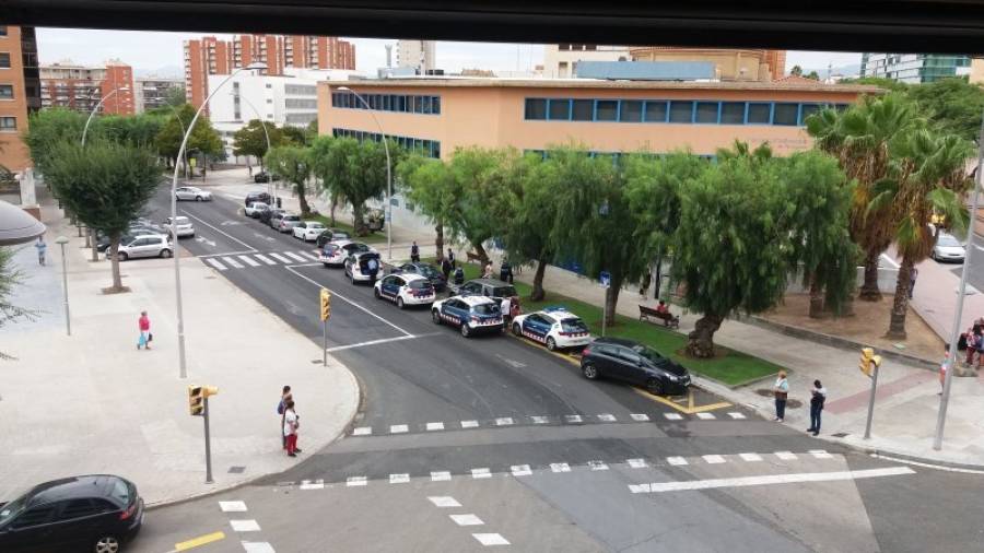 Vista general del amplio despliegue policial de ayer en la calle Enric d´Ossó, con patrullas logotipadas y otras con agentes de paisano. Foto: Àngel Juanpere