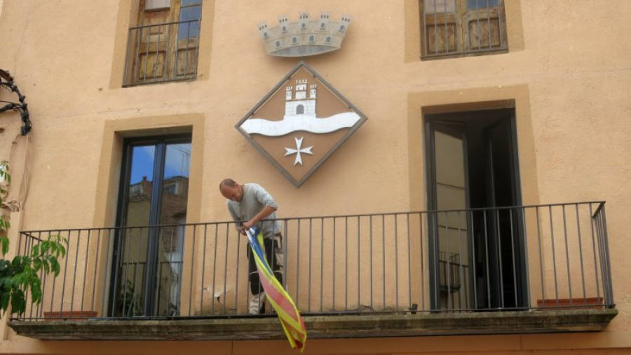 L'alcalde de Miravet, Toni Borrell, retira l'estelada del balcó de l'Ajuntament. Foto: ACN