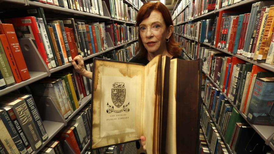 La periodista y escritora Susan Orlean, con un antiguo tomo, en la Biblioteca Pública de Los Ángeles.