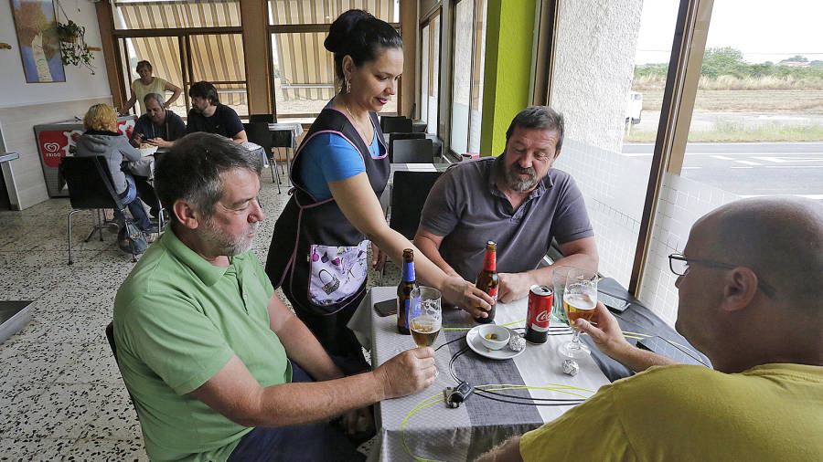 Francis Bel sirve unas cervezas a unos clientes en Ca l'Ermita, en Ferran. Foto: Llu&iacute;s Milian