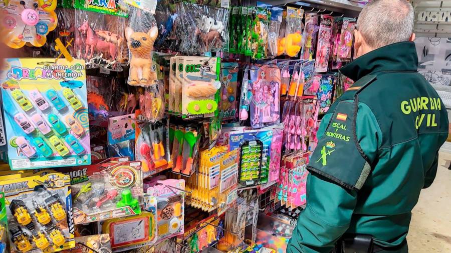 Un agente comprobando la legalidad de los juguetes de una tienda de Valls. FOTO: G.C.
