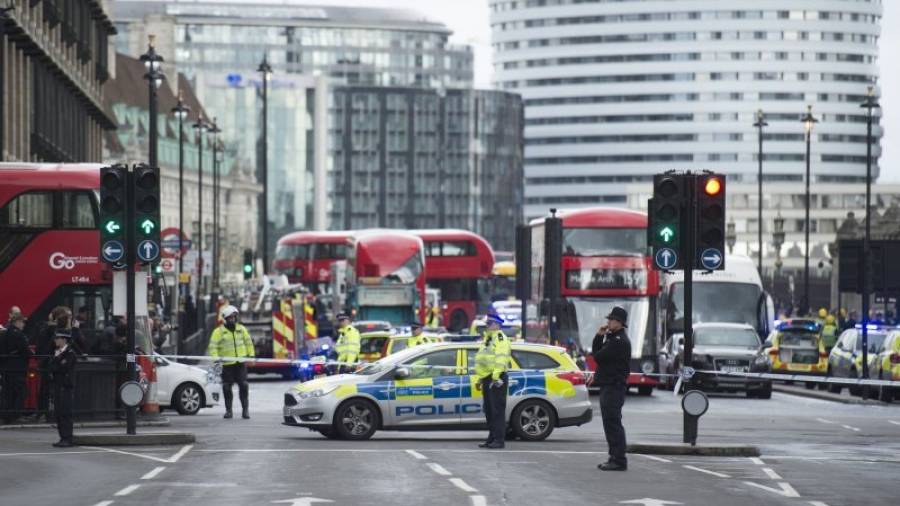 Agentes de policía británicos permanecen en guardia tras un tiroteo ante el Parlamento en Londres. Foto: EFE