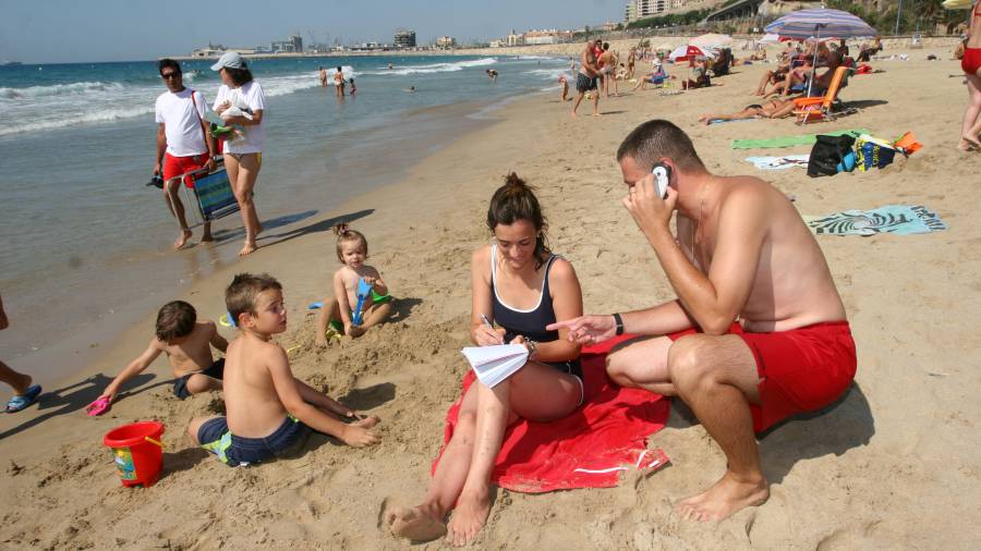 Un hombre hablando por teléfono en la playa del Miracle de Tarragona. Foto: lluís milián