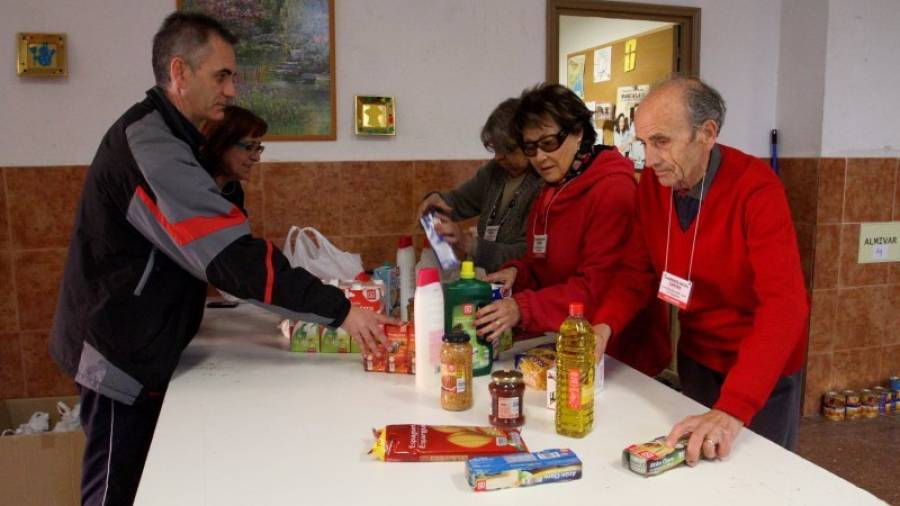 Un grupo de voluntarios de Cáritas recogen alimentos entre los vecinos del barrio de Sant Pere i Sant Pau de Tarragona para que a ninguna familia les falte en estas fiestas. Foto: Lluís Milián