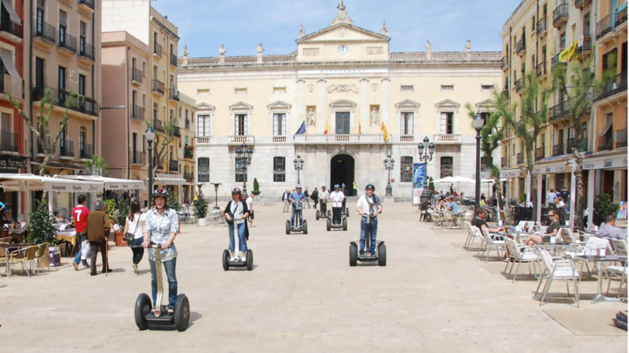 Un grupo de turistas a bordo de segways en la plaza de la Font de Tarragona, delante del Ayuntamiento, durante una ruta por la ciudad. FOTO: SEGWAY TARRAGONA