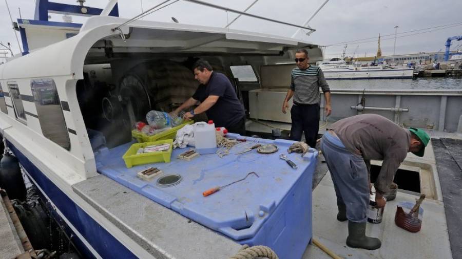 El armador Domingo Pedrol y sus trabajadores arreglan algunas de las cosas en mal estado de la embarcación La Guita I. Foto: Lluís Milián