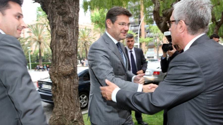 El ministro saluda al alcalde en presencia del decano de los abogados de Tarragona ?a la izquierda?. Foto: Lluís Milián
