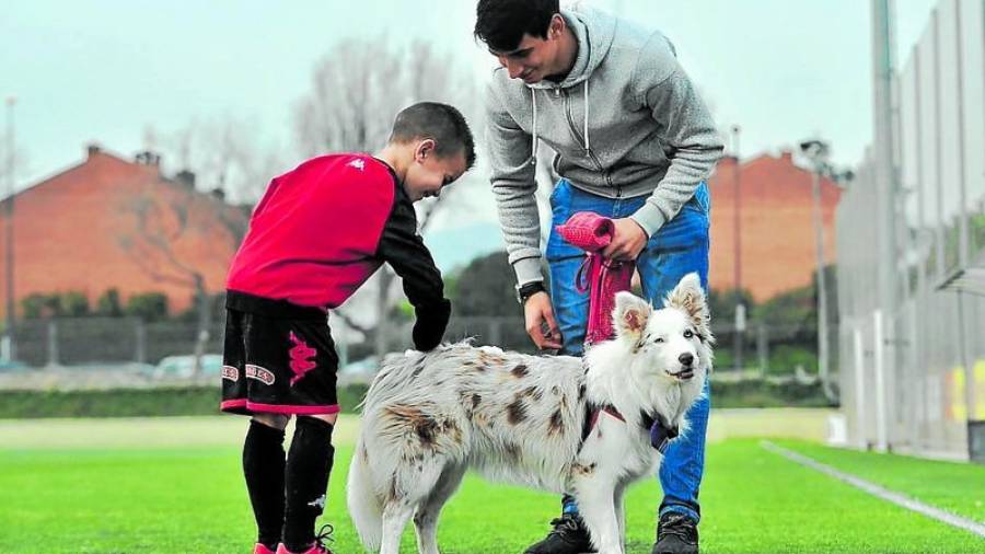 Manel Lora y un pequeño futbolista del CF Reus acarician a Nala. Foto: CF Reus