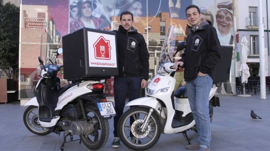 Sergi Dosaiguas (izquierda) e Ivan Gallisà, los dos socios de restaurantacasa.cat, junto a dos de las motocicletas de reparto de comida. Foto: Pere Ferré