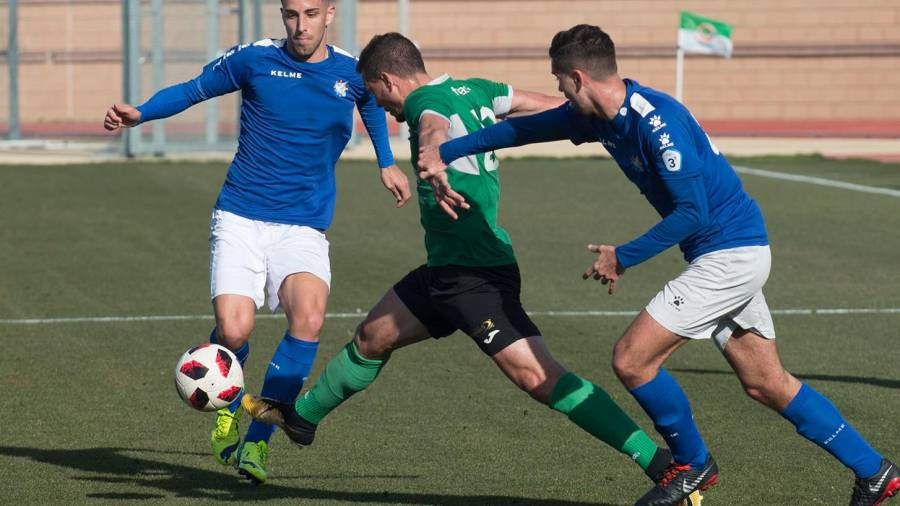 Masqué, entre dos rivales, en un partido disputado esta temporada por el FC Ascó. Foto: Joan Revillas