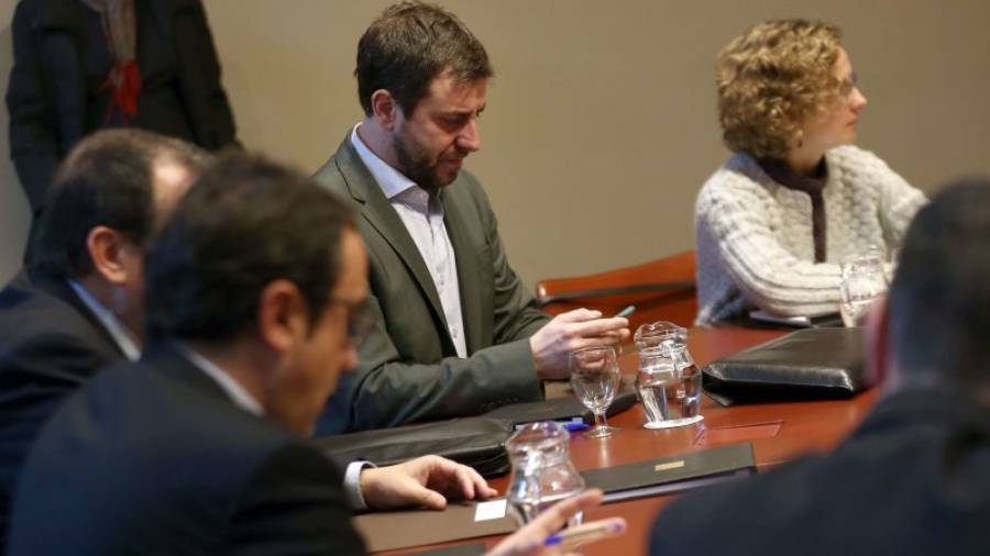 El conseller de Salut, Antoni Comín, observa el seu telèfon, durant la reunió que el govern de la Generalitat celebra habitualment cada dimarts. EFE